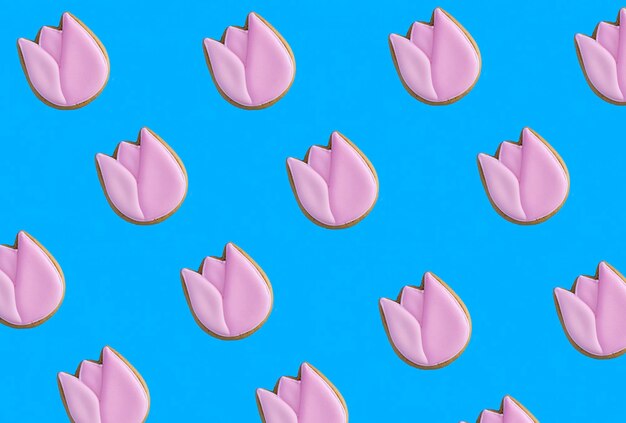 Fondo creativo de primavera Tulipán rosa en forma de pan de jengibre sobre fondo azul Patrón plano laico