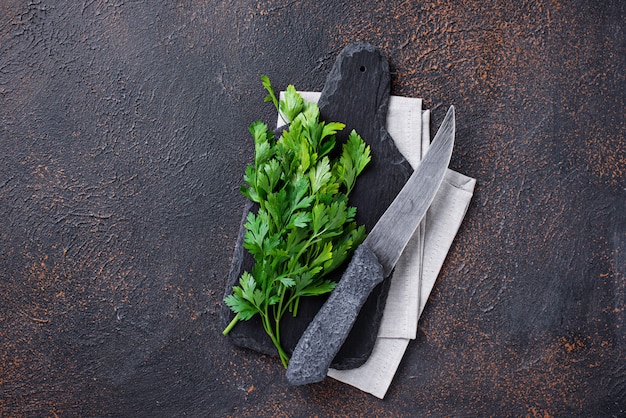 Fondo culinario con cuchillo, perejil y tabla de cortar.