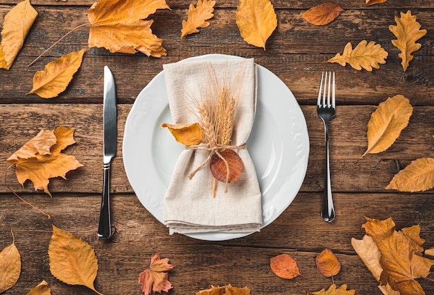 Fondo culinario festivo de otoño con un plato que sirve servilleta y cubiertos