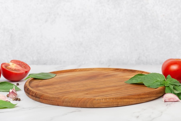 Foto fondo culinario ligero con tomates y albahaca de madera redonda