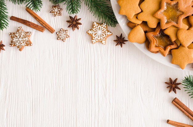 Fondo culinario con pan de jengibre de Navidad recién horneado, especias y ramas de abeto.