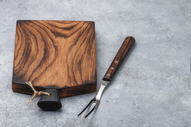 Fondo culinario. Tabla de cortar madera natural y tenedor para carne. copia espacio