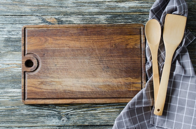 Fondo culinario con utensilios de cocina rústica en mesa de madera vintage.