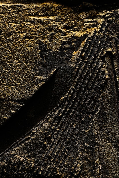 Fondo decorativo de putty de oro negro Textura de pared con pasta de relleno aplicada con espátula Trazos caóticos y trazos sobre yeso Diseño creativo patrón de piedra cementxA