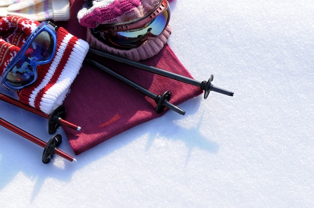 Foto fondo de deportes de invierno con bastones de esquí, gafas, sombreros y guantes