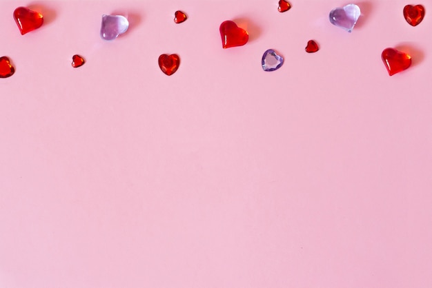 El fondo del día de San Valentín. Borde de hermosos corazones diferentes sobre un fondo rosa