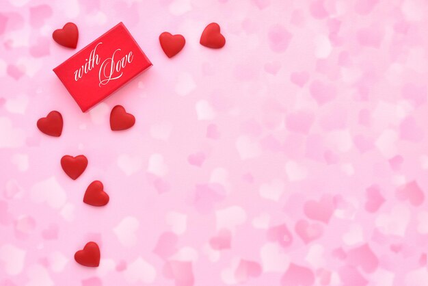 Foto fondo del día de san valentín caja de regalo roja y corazones en fondo festivo