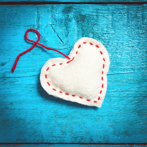 Foto fondo del día de san valentín. corazones tejidos multicolores se encuentran en los viejos tableros azules.