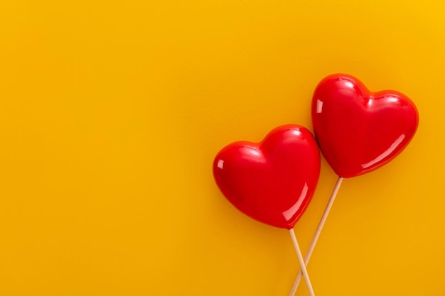 Foto fondo del día de san valentín con dos corazones rojos sobre fondo pastel