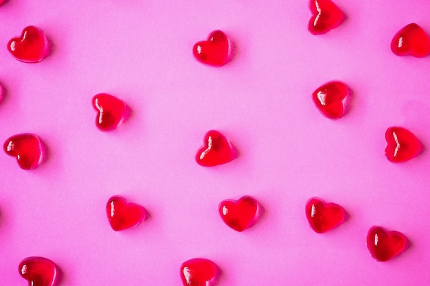Fondo del día de San Valentín con dulces en forma de corazón sobre fondo rosa