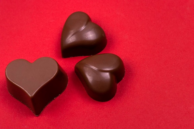 Fondo del día de San Valentín Primer plano de chocolates en forma de corazón en fieltro rojo