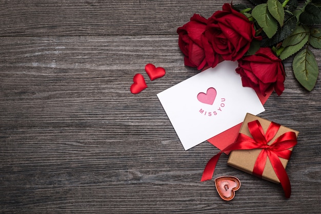 Fondo del día de San Valentín, tarjeta del día de San Valentín con rosas y regalos en el tablero de madera