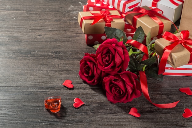 Fondo del día de San Valentín, tarjeta del día de San Valentín con rosas y regalos en el tablero de madera