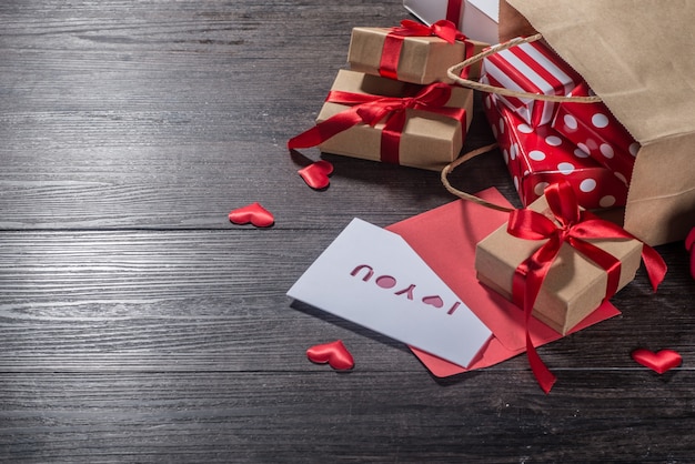 Fondo del día de San Valentín, tarjeta del día de San Valentín con rosas y regalos en el tablero de madera