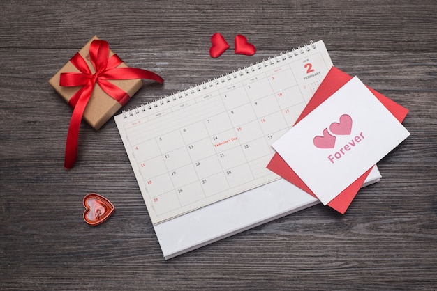 Fondo del día de San Valentín, tarjeta y regalo en el calendario