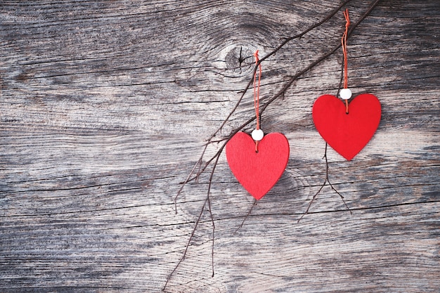 Fondo del día de tarjetas del día de San Valentín con los corazones rojos en rama. Copia espacio