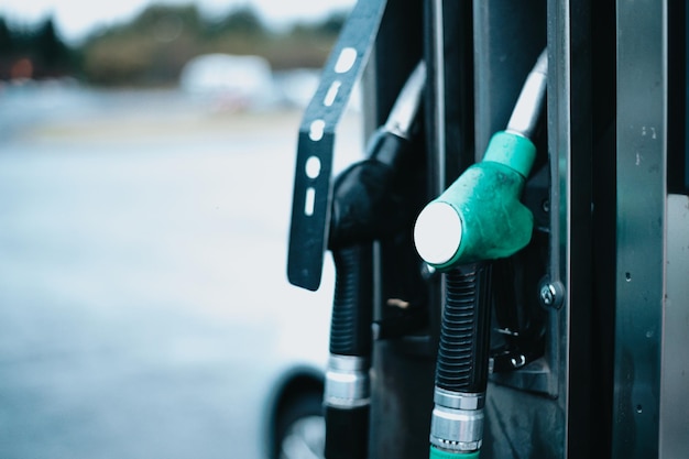 Fondo del dispensador de gasolina CombustibleDistribuidor de gasolina y diésel en la gasolinera Boquillas de bomba de gas Pistola de llenado de gasolina primer plano en la gasolineraBoquillas de llenado de bomba de gasolina coloridas