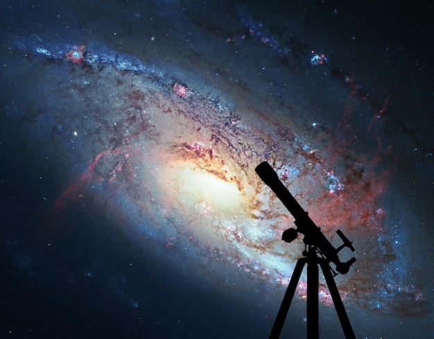 Foto fondo espacial con silueta de telescopio. galaxia espiral m106, en la constelación canes venatici. los elementos de esta imagen son proporcionados por la nasa.