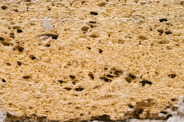 El fondo está hecho de piedra beige Ladrillo decorativo Textura porosa