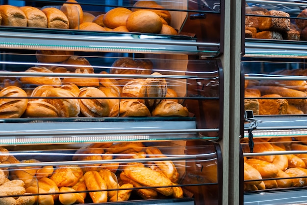 Fondo - estantes en una tienda de abarrotes con pan fresco de diferentes variedades