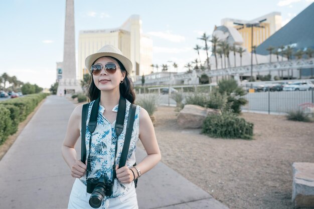 fondo con estatuas egipcias en fila en el hotel y casino en Las Vegas Nevada. joven fotógrafa de viajes llevar cámara caminando por la calle de la ciudad al aire libre relajarse. mujer turista sonriente disfruta del verano