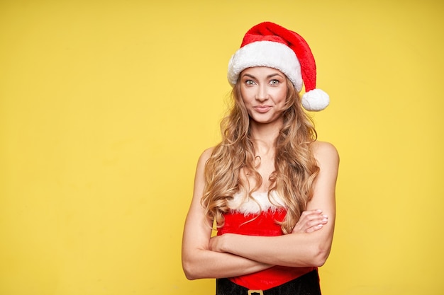 Fondo de estudio amarillo de Navidad Santa Hat mujer con smartphone en mano
