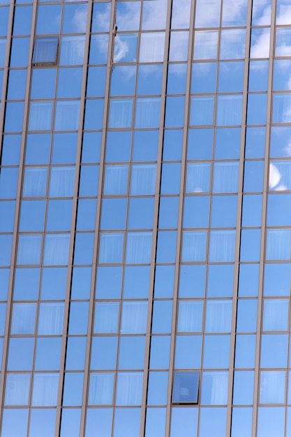 Fondo de fachada de vidrio con reflejo de cielo azul. Arquitectura y estructura modernas. Construcción y diseño. Propiedad comercial o inmobiliaria. Concepto de éxito y futuro.