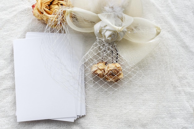 Fondo femenino de moda en tela blanca flores un sombrero y una postal vacía Fondo femenino de boda En blanco para una postal