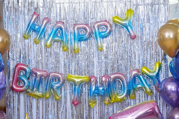 Foto fondo festivo con letras en inglés feliz cumpleaños, brillo y globos.