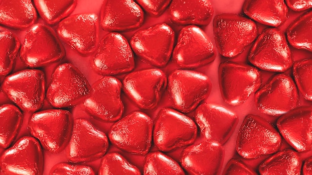 Foto fondo festivo con muchos chocolates envueltos en forma de corazón