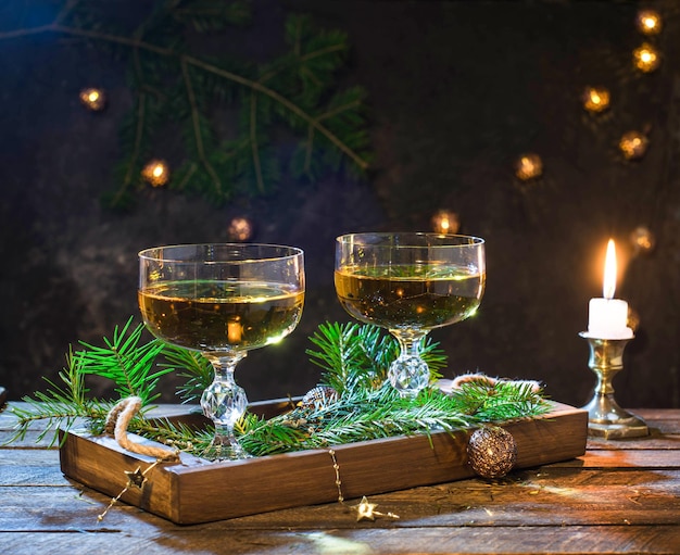 Fondo festivo de Navidad o Año Nuevo con copas de vino o champán en bandeja de madera.