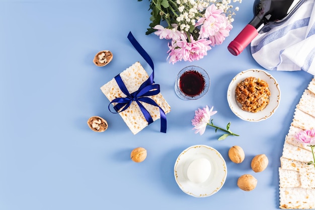 Fondo festivo de los símbolos tradicionales de la Pascua judía y productos de la festividad en un fondo azul vista superior diseño plano un espacio de copia