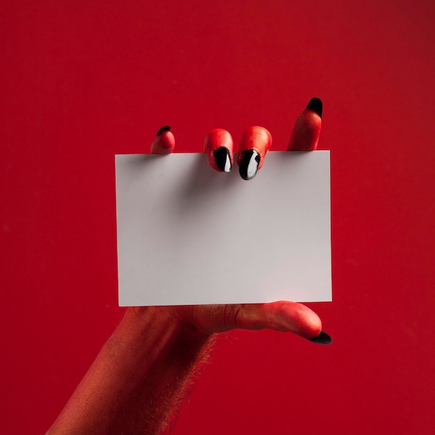 Fondo de fiesta de Halloween de papel en blanco con mano de diablo espeluznante rojo