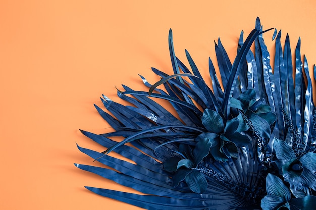 El fondo de la flor es naranja, con flores artificiales en azul. Espacio para texto. Color de tendencia.