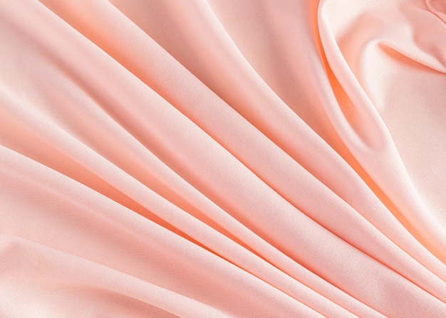 Fondo de flor de melocotón festivo elegante Imagen de fondo de tela de fábrica Plegables pliegues suaves Un espacio de copia El color del año 2024 Peach Fuzz