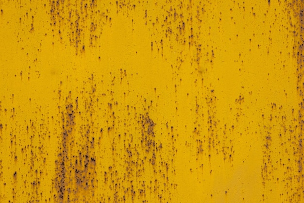 Fondo de fotograma completo y textura de chapa de acero pintada de amarillo con múltiples manchas de óxido