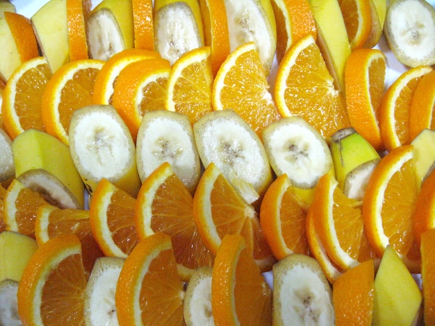 Fondo de la fruta cortada de los plátanos y las naranjas