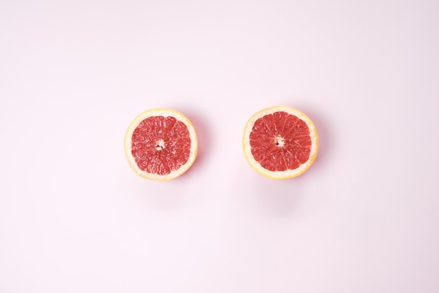 Fondo de fruta mínimo Vista superior de pomelo de frutas cítricas en rodajas en la mesa rosa Vista superior endecha plana