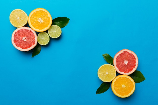 Fondo de frutas Frutas frescas coloridas en mesa de colores Naranja limón pomelo Espacio para texto concepto saludable Espacio de copia de vista superior plana
