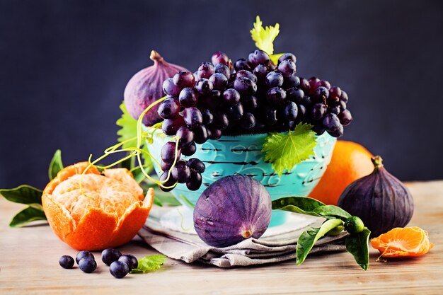 Fondo de frutas con uva, naranja, higos sobre fondo de pizarra. Comida sana