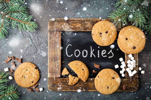 Foto fondo con galletas de chispas de chocolate caseras y malvaviscos. marco de comida navideña.