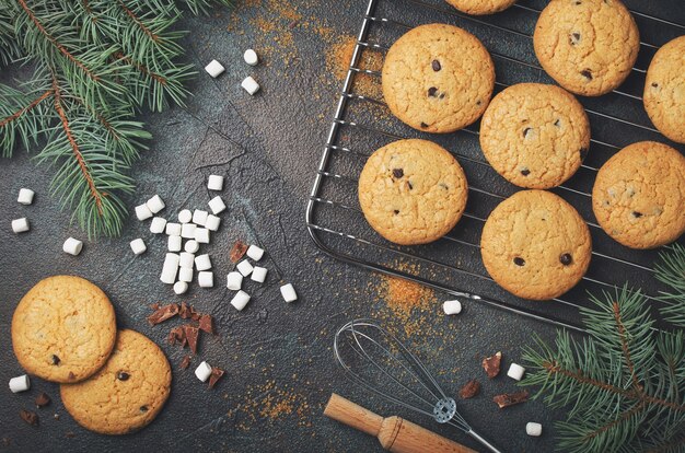 Fondo con galletas de chispas de chocolate caseras y malvaviscos. Marco de comida navideña.