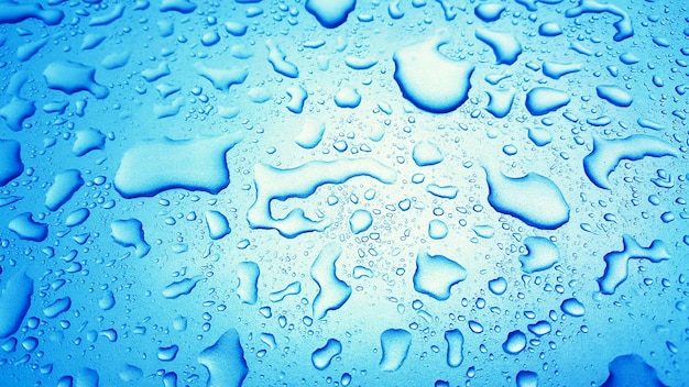 Fondo de gotas de agua en la superficie azul brillante Gotas de lluvia en textura azul para drin cosméticos