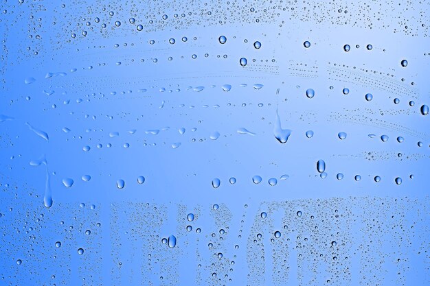 Fondo de gotas frescas vidrio azul / fondo lluvioso húmedo, gotas de agua vidrio transparente azul