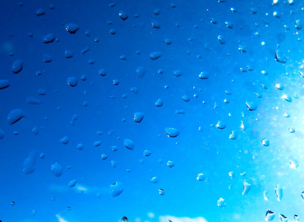 Fondo gotas de lluvia en la ventana con cielo azul