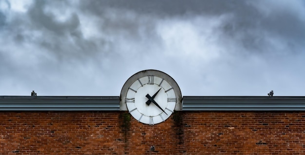 Fondo con gran reloj en el techo de la casa de ladrillo rojo Concepto de tiempo