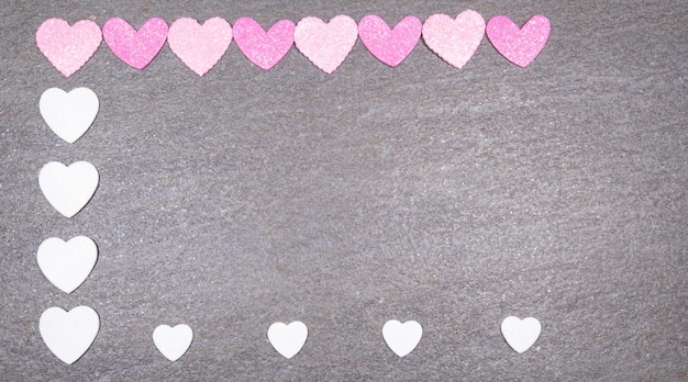 Fondo de granito gris con corazones rosas y blancos para el día de san valentín Concepto de amor y día de san valentín