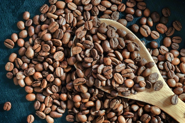 Fondo de granos de café tostados y cuchara de madera de cerca Vista desde arriba