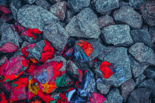 Fondo gris piedras y rocas pintadas en rojo moteado, vista desde arriba