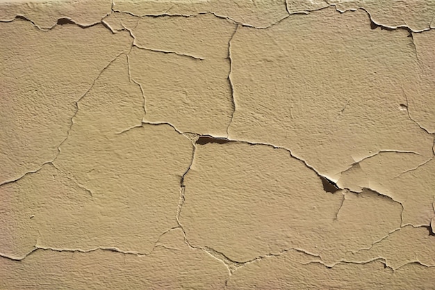 Fondo grueso de paredes peladas agrietadas con masilla pelada en tonos beige